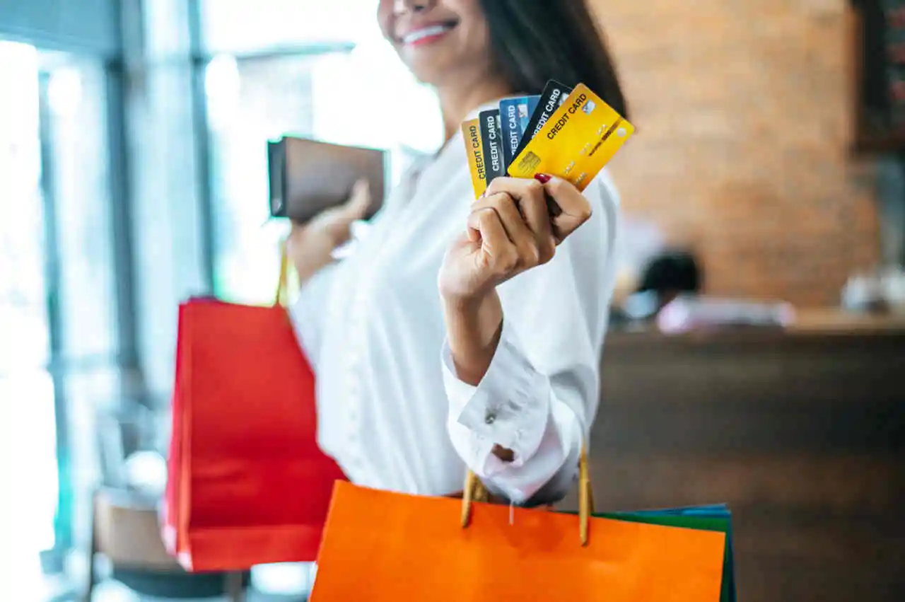 mulher jovem com bolsas e cartões de crédito